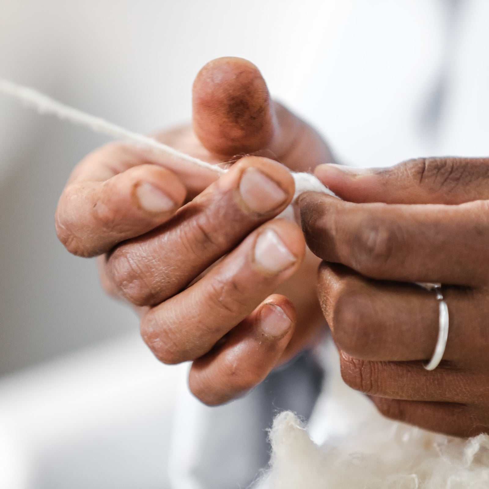 Hände bei der Verarbeitung von fairer Bio-Baumwolle