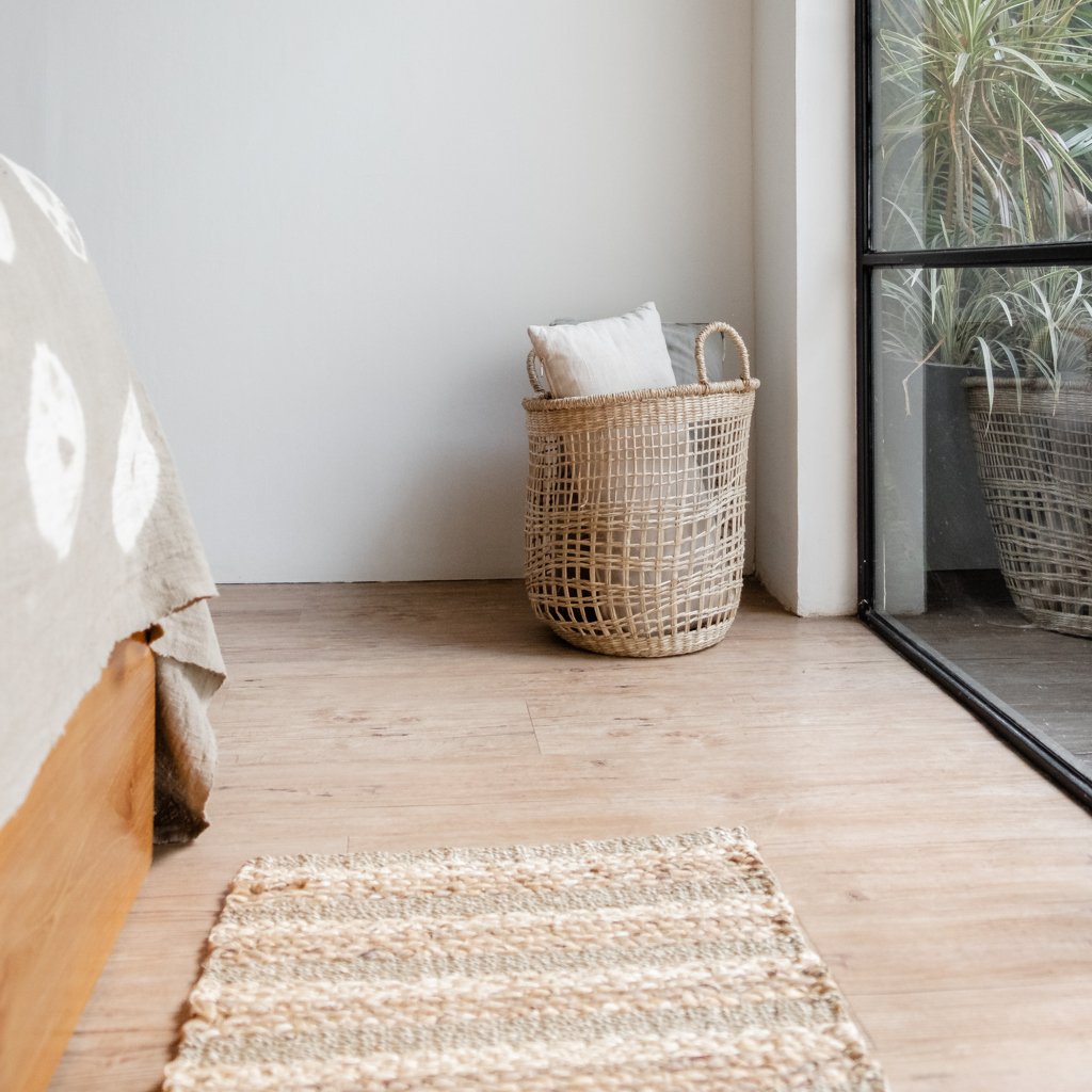 Teppich Wasserhyazinthe vor Bett mit Wäschekorb geflochten